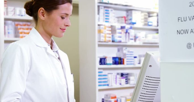 Smiling pharmacist holding barcode scanner in pharmacy