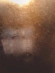 Blurry water drops on sunshine ffrozen window glass background