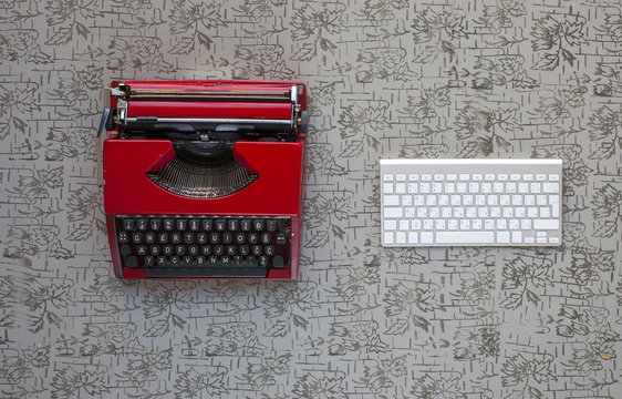 Old Typewriter And A New Keyboard On Vintage Wooden Background Photographed In Daylight. New And Old Technology