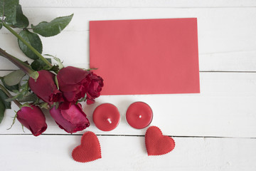 Rose , red heart shape, candles and red paper on white table. co