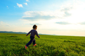 Young child running through a meadow