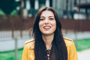 Portrait of young beautiful caucasian brown hair woman outdoor in the city looking at camera...