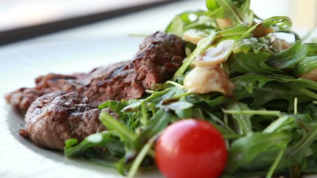 fresh juicy salad with ruccola beef and cherry tomatoes served for a romantic dinner in luxury restaurant 