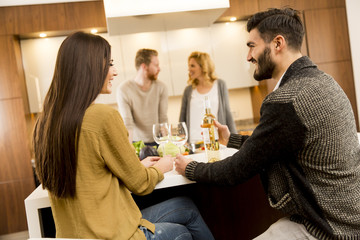 Group of young people having dinner and drinking wine in modern