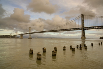 San Francisco-Oakland Bay Bridge with Moody Skies From The Embarcadero.