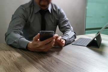 businessman using smart phone and keyboard dock digital tablet.W