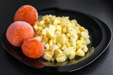 potatoes and tomatoes on a black plate
