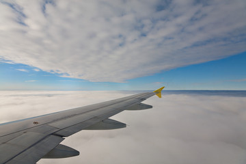 Fototapeta na wymiar Tragfläche eines Flugzeuges zwischen den Wolken