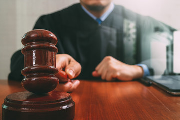 justice and law concept.Male judge in a courtroom striking the g