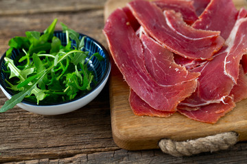 jamon and rucola on wooden surface