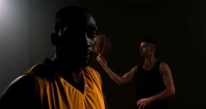 Portrait of basketball player while competitor spinning ball in background 4k
