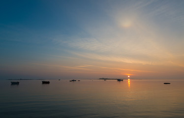 Sonnenaufgang an der bretonischen Küste, zwei Fischer auf ihrem Boot