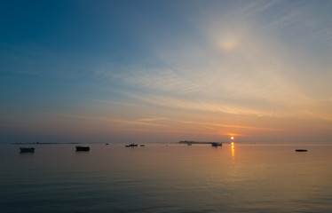 Fototapeta premium Sonnenaufgang an der bretonischen Küste, zwei Fischer auf ihrem Boot