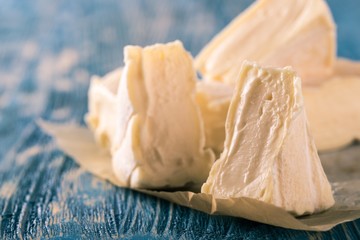 Few portions of camembert cheese on blue wooden board