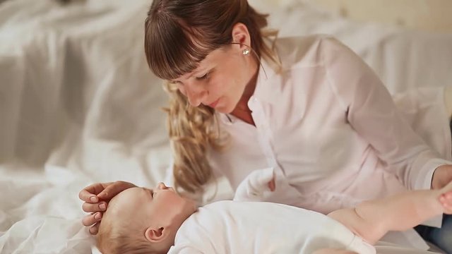 Mother's hands tenderly kissing little feet of her baby