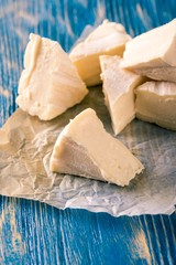 Several portions of camembert on blue wooden board
