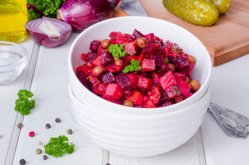 Traditional Russian and Ukrainian vegetable salad Vinaigrette. Salad with beets, potatoes, carrots, pickles and peas.