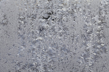 Frozen glass, frost at transparent surface, closeup textured background