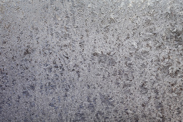 Frozen glass, frost at transparent surface, closeup textured background