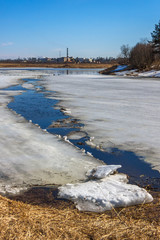 The ice on the river breaks before drifting ice. Spring. On the horizon of the plant pipe. © fabrikanes