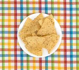 Tortilla chips on a plate and a colorful place mat