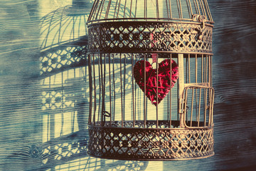 Heart inside the bird cage. Vintage background. Love/romance concept.