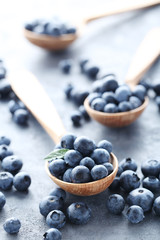 Ripe and tasty blueberries on grey wooden table