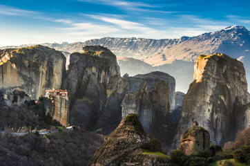 Fototapeta premium Breathtaking view of Meteora Roussanou Monastery at sunset, Greece. Geological formations of big rocks with Monasteries on top of them.