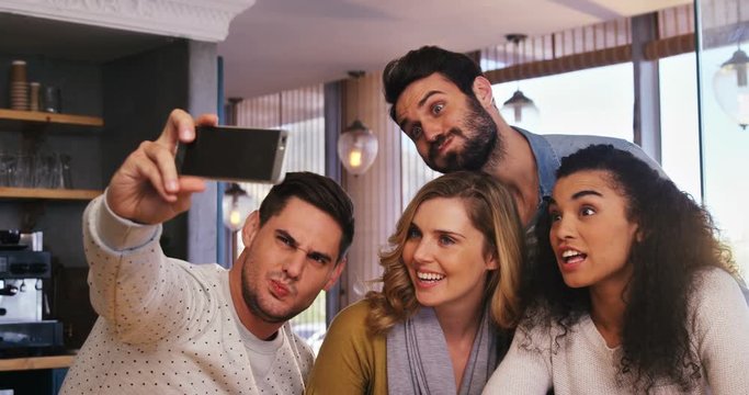 Group of friends taking a selfie in cafÃ© 4k