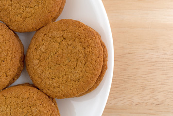 Cheesecake filled pumpkin cookies on a plate atop a wood table.