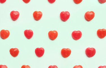 Red Valentine's day heart shape candy pattern on green pastel paper color background. Love Concept. colorful hipster style. top view.