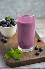 Blueberry and banana smoothie with oatmeal on the rustic wooden table, selective focus