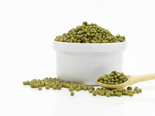 organic mung beans in the white bowl and wood spoon isolated on white background