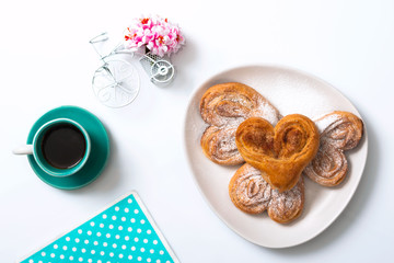 Buns with cinnamon and powdered sugar and a cup of coffee and a