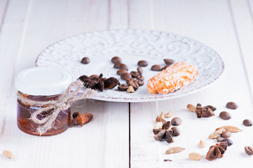 small jar with honey on a vintage saucer decorated with seeds of anise and cardamom coffee