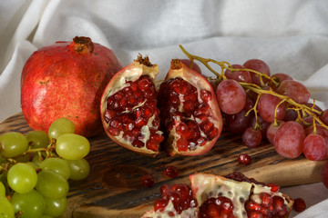 Red and green grapes with pomegranate on a kitchen table