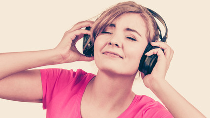 Naklejka premium Woman in big headphones listening music