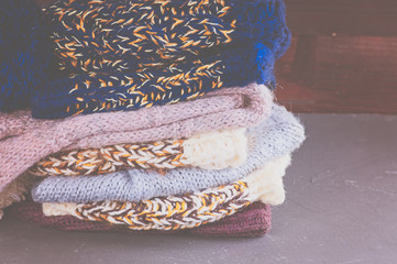 pile of multicolored knitted woolen scarves and warm hats