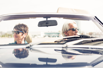 Senior Couple Driving A Convertible Classic Car