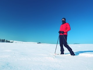 Fototapeta na wymiar Tourist with snowshoes walk in snowy drift. Sunny freeze weather.