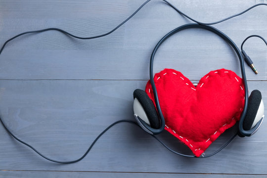 Red homemade heart with headphones on Valentine's Day.