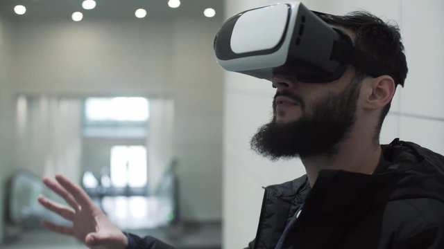 Young Man using virtual reality goggles in shopping center