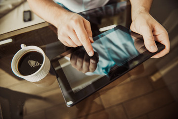 Young successful man sitting in a cafe with  cup of coffee