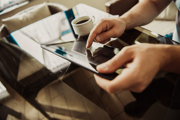 Young successful man sitting in a cafe with  cup of coffee