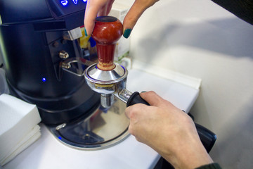 woman's hands pressing ground coffee before making it