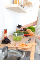 Fresh vegetables on the cutting board are falling in the pot, concept of cooking