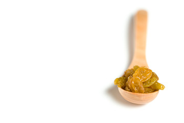 A driend raisin in a wooden spoon isolated over white background