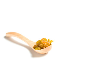 A driend raisin in a wooden spoon isolated over white background