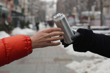 Hand takes the can against the panorama of the city