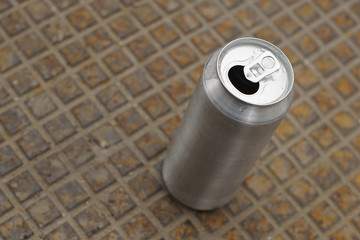 Empty can for beer or soda on rusty metal plate
